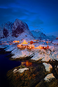 著名的旅游景点汉诺伊渔村洛福腾岛上,挪威红色的罗布屋,冬天的雪晚上照亮挪威洛福滕岛的汉诺伊渔村图片