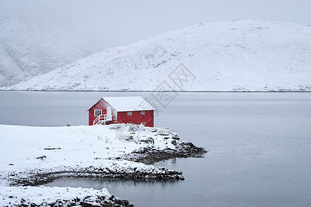 传统的红色Rorbu房子峡湾岸边与大雪冬季挪威洛福腾群岛冬天的红罗布房子,洛芬岛,挪威图片