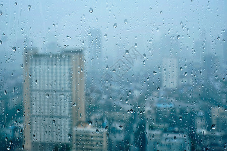 雨水滴窗户璃纹理上,背景摩天大楼雨点落窗户上图片