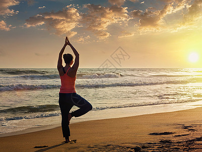 户外瑜伽运动健康的女人哈他瑜伽,阿莎娜,vrikshasana,热带海滩日落轻的运动健康的女人海滩上瑜伽树图片