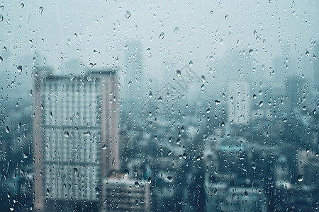 雨水滴窗户璃纹理上,背景摩天大楼雨点落窗户上图片