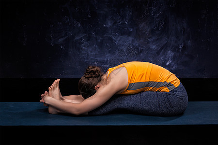 运动健康的女人练阿什唐加维尼亚萨瑜伽背部弯曲阿萨纳帕西莫塔纳坐前弯运动的女人练阿什唐加维尼亚萨瑜伽图片