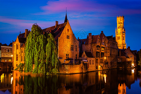 著名的BrugesRozenhoedkaai与钟楼旧房子沿运河与树木夜间布鲁日,比利时比利时布鲁日著名的景色图片
