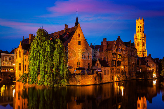 著名的BrugesRozenhoedkaai与钟楼旧房子沿运河与树木夜间布鲁日,比利时比利时布鲁日著名的景色图片