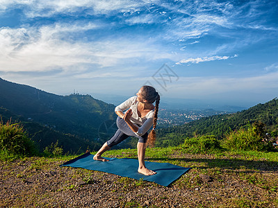 运动健康的女人练阿什唐加维尼亚萨瑜伽阿萨纳utthitaParsvakonasana静脉曲张延伸的侧角姿势户外的山区早上图片