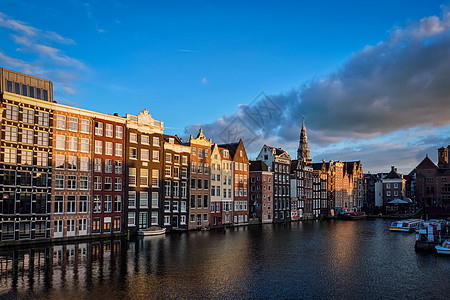 阿姆斯特丹运河码头上的房屋旅游船荷兰阿姆斯特丹阿姆斯特丹运河码头上的Hhouse旅游船太阳上的Damrak图片