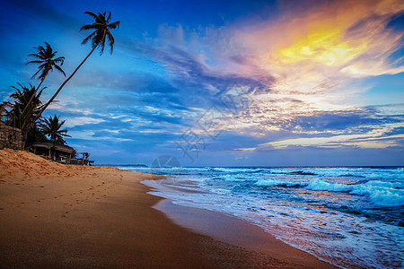 海滩度假浪漫背景日落热带海滩与戏剧的云天斯里兰卡热带海滩的日落图片