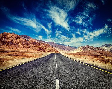 复古效果过滤了嬉皮士风格的道路形象山区喜马拉雅山戏剧的云蓝天拉达克,查谟克什米尔,印度喜马拉雅山脉的道路图片