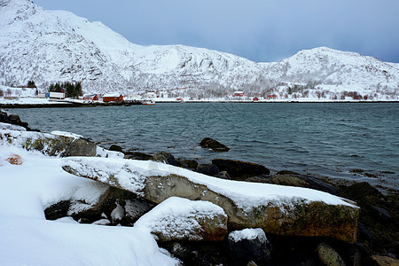 传统的红色Rorbu房子峡湾岸边冬天的雪挪威洛福腾群岛冬天挪威的红色Rorbu房子图片