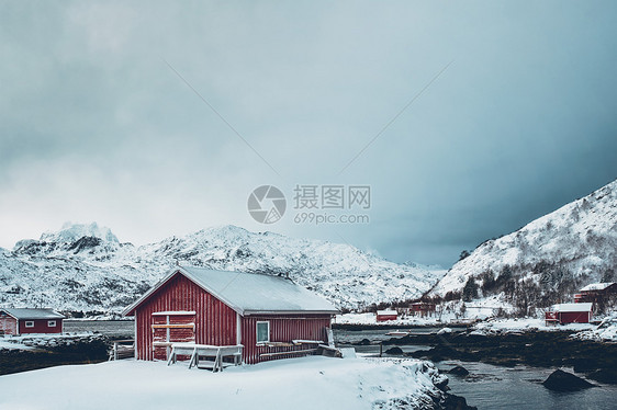 传统的红色Rorbu房子峡湾岸边与大雪冬季挪威洛福腾群岛冬天的红罗布房子,洛芬岛,挪威图片