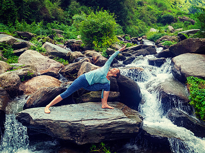 运动健康的女人练瑜伽阿萨纳utthitaParsvakonasana延伸的侧角姿势户外的水复古效果过滤时尚风格的形象图片