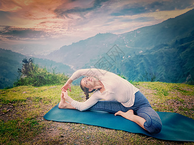 户外瑜伽轻的运动健康的女人哈他瑜伽阿萨纳亚努西萨纳头部膝盖的姿势复古效果过滤时尚风格的形象轻运动健康的图片