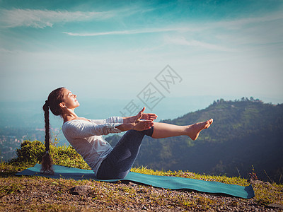 户外瑜伽轻的运动健康的妇女阿什唐加维尼亚萨瑜伽阿萨纳瓦萨纳船的姿势喜马拉雅山脉的山区,上午的希马哈尔邦,印度复古图片