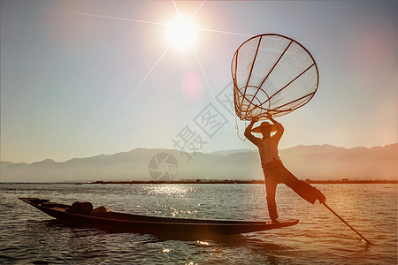 缅甸旅游景点地标缅甸传统渔民inle湖,缅甸著名的独特的单腿划船风格日落光泄漏镜头耀斑缅甸inle湖的传统缅甸图片