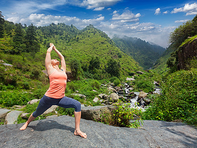 瑜伽户外运动健康的女人阿什唐加维尼亚萨瑜伽阿萨纳维拉哈德拉萨纳1战士姿态瀑布喜马拉雅山脉女人阿什唐加维尼亚萨瑜伽阿图片