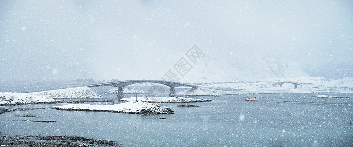 弗莱德万桥冬季大雪中与渔船挪威洛福腾群岛挪威洛福滕岛的降雪图片