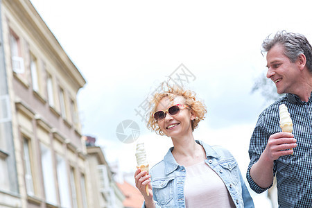 微笑的中夫妇阳光明媚的日子里着冰淇淋锥图片