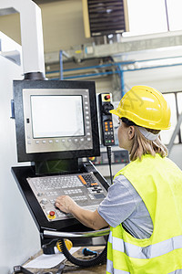 女工工厂控制板上操作机械图片