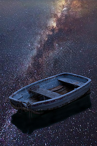 令人惊叹的充满活力的银河复合图像,单艇漂浮湖上,银河反射平静的水中图片