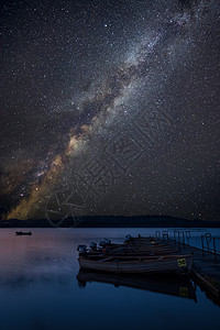 令人惊叹的充满活力的银河复合图像静湖景观与船码头图片