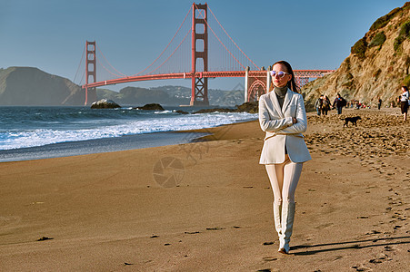美国加利福尼亚州旧金山金门大桥附近贝克海滩上行走的女人图片
