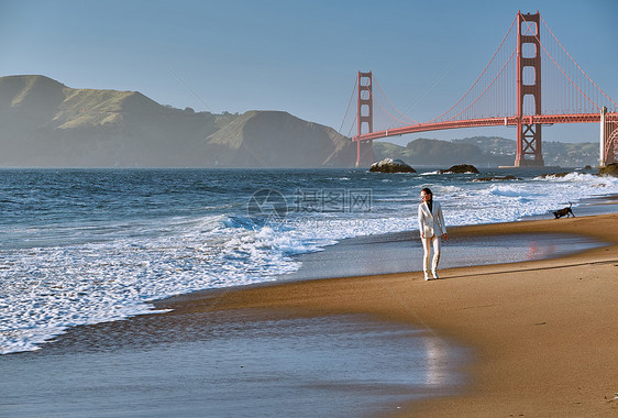 美国加利福尼亚州旧金山金门大桥附近贝克海滩上行走的女人图片