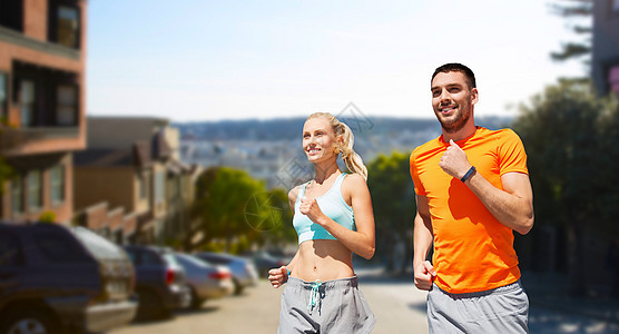健身,运动健康的生活方式微笑夫妇与心率手表运行旧金山城市背景微笑的夫妇跑过旧金山图片