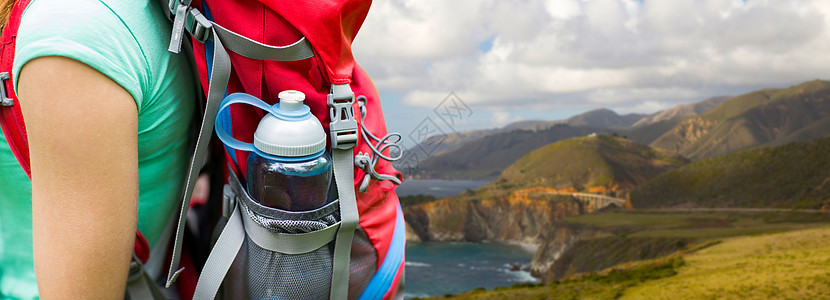 旅行,旅游,徒步旅行人们的加州大海岸的比克斯比克里克桥上,背包口袋里装着水瓶的女人特写把带水瓶的女人关背包里图片