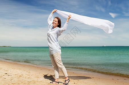 人与休闲的快乐的女人与披肩风中挥动夏季海滩快乐的女人,披肩海滩上迎风飘扬图片