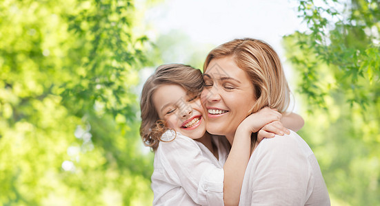 家庭,母亲人的幸福的母亲女儿拥抱绿色的自然背景母女绿色背景下拥抱图片