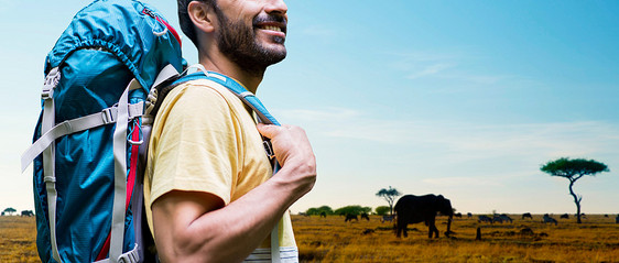 冒险,旅行,旅游,徒步旅行人的非洲大草原背景下,带着背包的微笑的动物身上把带背包的人关草原上图片
