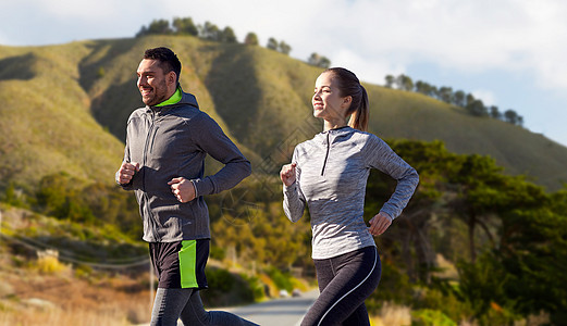 健身,运动,人健康的生活方式幸福的夫妇跑过大丘道路背景加利福尼亚快乐的夫妇户外跑步图片