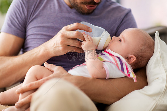 家庭,父母人的亲密的父亲喂养小女儿与婴儿配方奶粉瓶家里父亲瓶子喂养婴儿图片