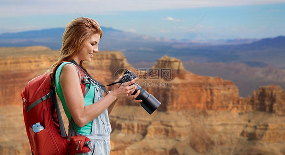旅行,旅游摄影快乐的轻妇女背包相机拍摄大峡谷公园的背景大峡谷带背包照相机的女人图片