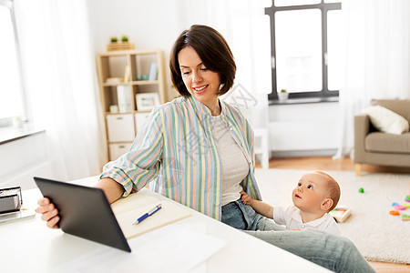 多任务,自由职业母亲的工作母亲与平板电脑电脑婴儿家里工作母亲与平板电脑婴儿家图片