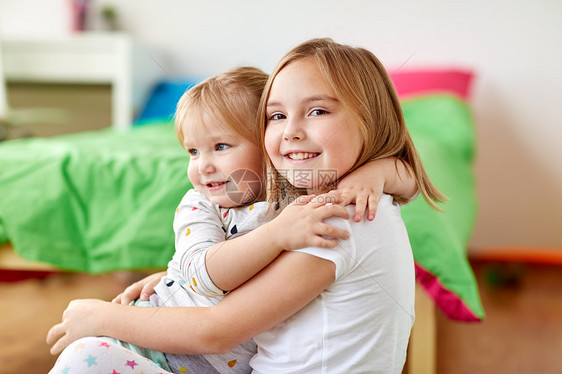 童,家庭,表情人的快乐的小女孩姐妹拥抱家里快乐的小女孩姐妹家里拥抱图片