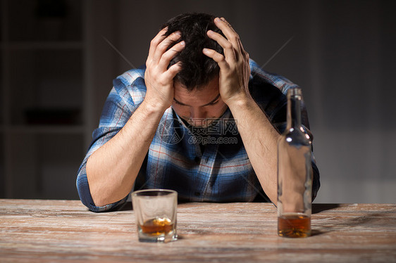 酒精中,酒精成瘾人的男酒精与瓶子璃饮用威士忌晚上晚上喝威士忌的酒鬼图片