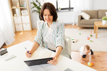 多任务,自由职业母亲的工作母亲与平板电脑电脑婴儿家里工作母亲与平板电脑婴儿家图片