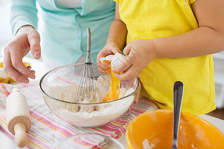 家庭,烹饪,烘焙人们的亲密的母亲小女儿打破鸡蛋碗制作家里的厨房母女家里厨房图片
