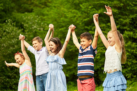 童友谊的快乐的孩子夏季公园举手快乐的孩子夏天的公园里举手图片