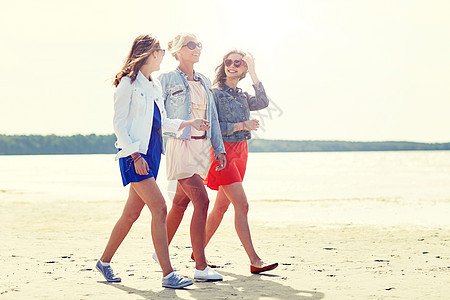 暑假,假期,旅行人的群微笑的轻女朋友,戴着太阳镜休闲服,沿着海滩散步海滩上群微笑的轻女朋友图片