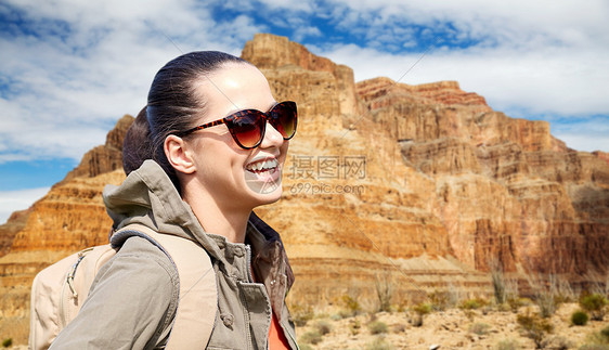 冒险,旅行,旅游,徒步旅行人的微笑的轻女人带着背包大峡谷公园的背景带着背包大峡谷上空微笑的女人图片