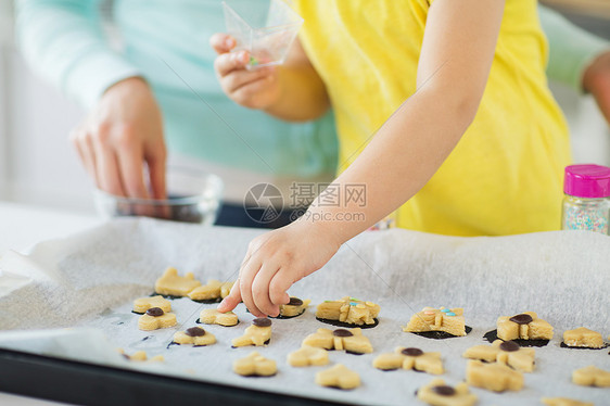 家庭,烹饪烘焙母亲小女儿家庭厨房的托盘上装饰饼干母亲女儿家饼干图片