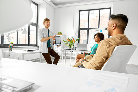 商业,创业,计划人的人展示平板电脑电脑给创意队办公室会议演示男子向办公室的创意队展示平板电脑图片