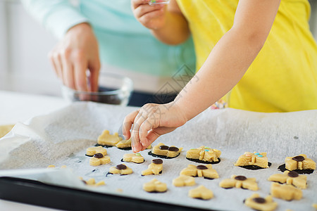 家庭,烹饪烘焙母亲小女儿家庭厨房的托盘上装饰饼干母亲女儿家饼干图片