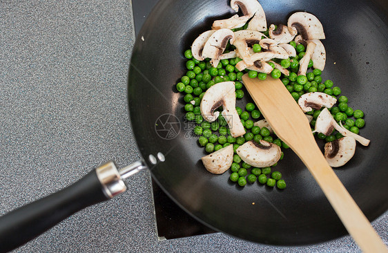 食物,烹饪烹饪蘑菇与豌豆煎锅上的炊具烹饪板上煎锅中的食物图片