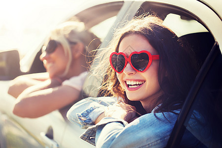 暑假,情人节,旅行,公路旅行人们的快乐的十几岁的女孩轻的女海边的汽车上的心形太阳镜快乐的十几岁的女孩海边图片