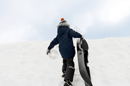 童,雪橇季节男孩与雪橇攀登雪山冬天冬天带着雪橇爬雪山的小男孩图片