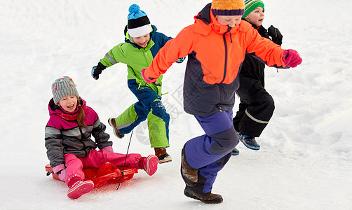童,休闲季节的群快乐的孩子穿着冬天的衣服,雪橇户外玩得很开心快乐的孩子冬天玩雪橇户外玩图片