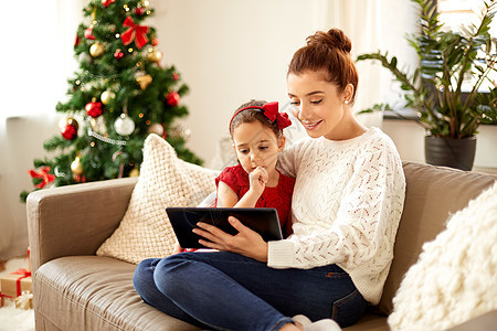 诞节,技术家庭快乐的母亲小女儿家里用平板电脑电脑诞节平板电脑的母女图片